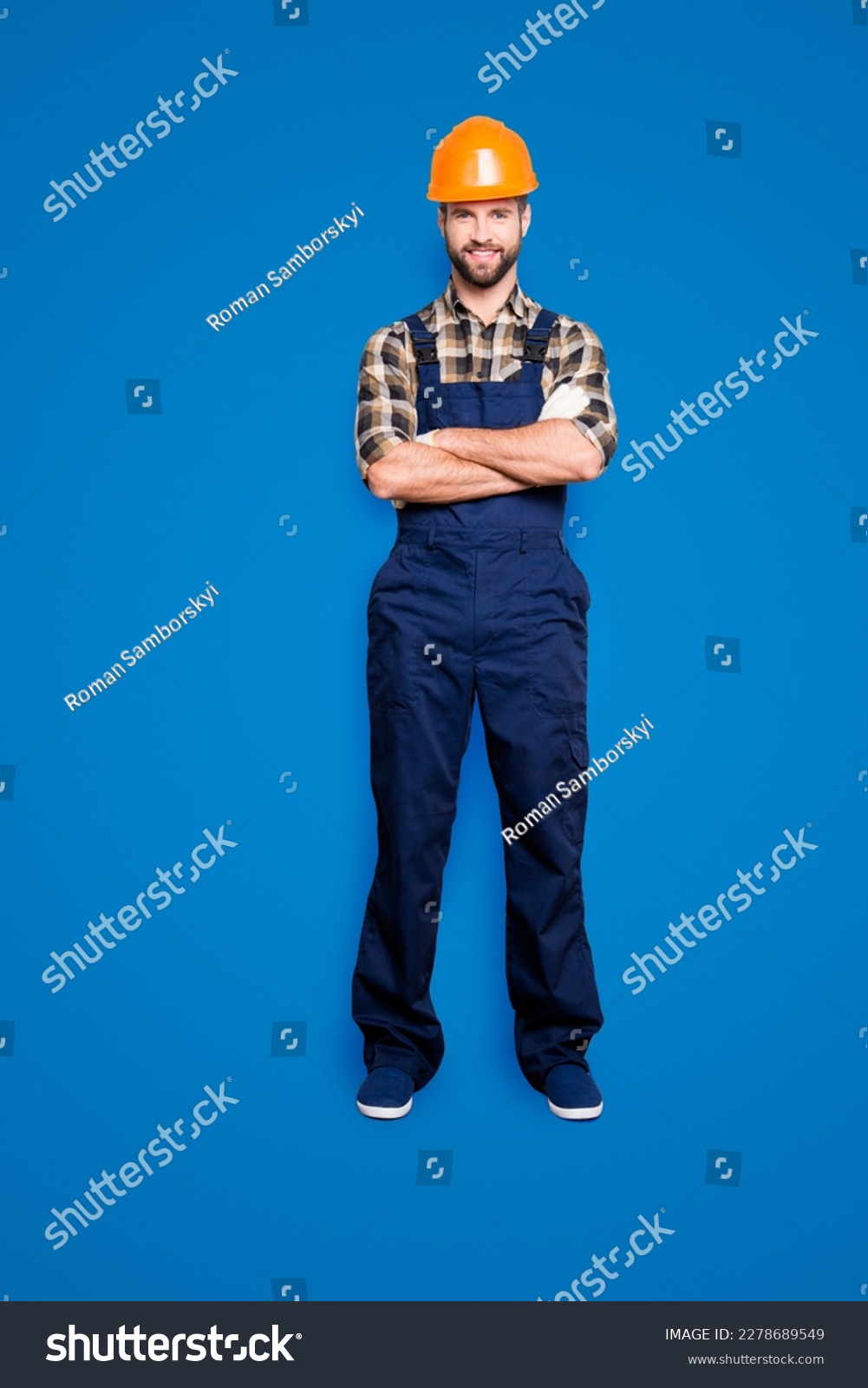 Full size fullbody portrait of cheerful joyful repairer in shirt and overall, having his arms crossed, looking at camera, isolated on grey background #2278689549