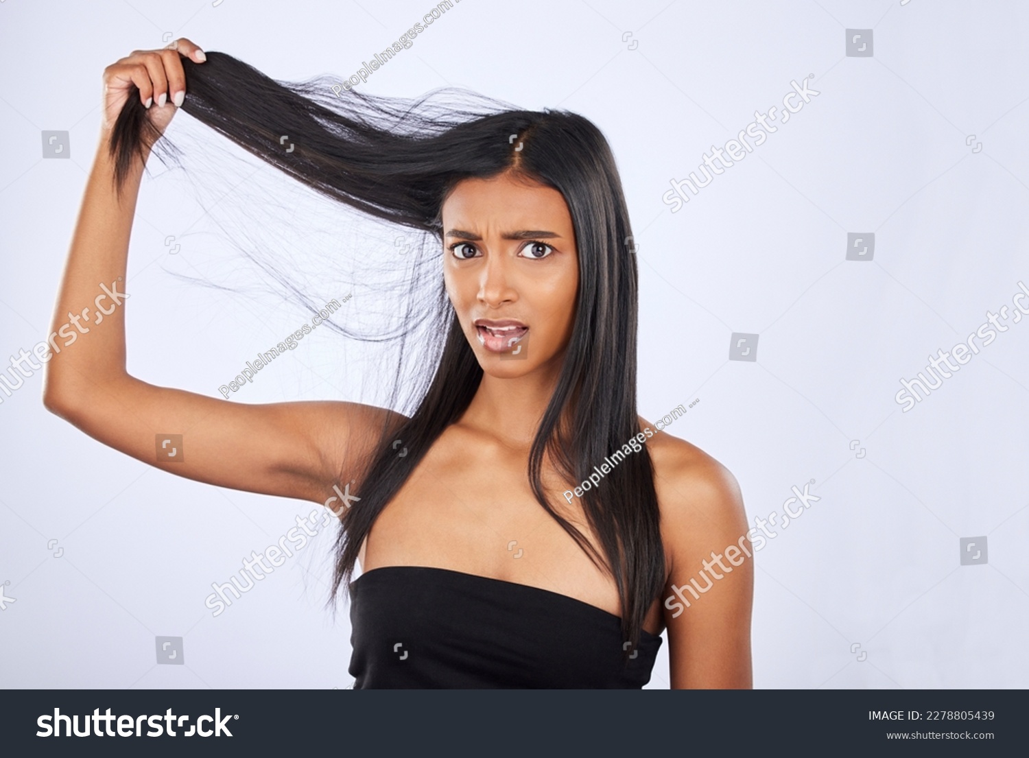 Hair damage, breakage and portrait of a frustrated woman isolated on a white background in studio. Bad, unhappy and an Indian girl sad about split ends, tangled hairstyle and frizzy haircare #2278805439