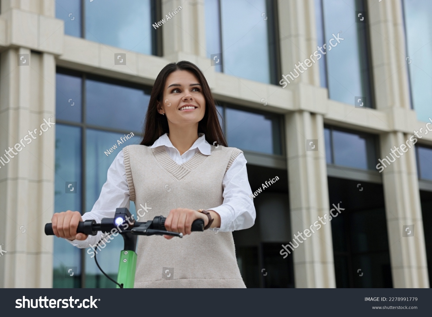 Businesswoman riding electric kick scooter on city street, space for text #2278991779