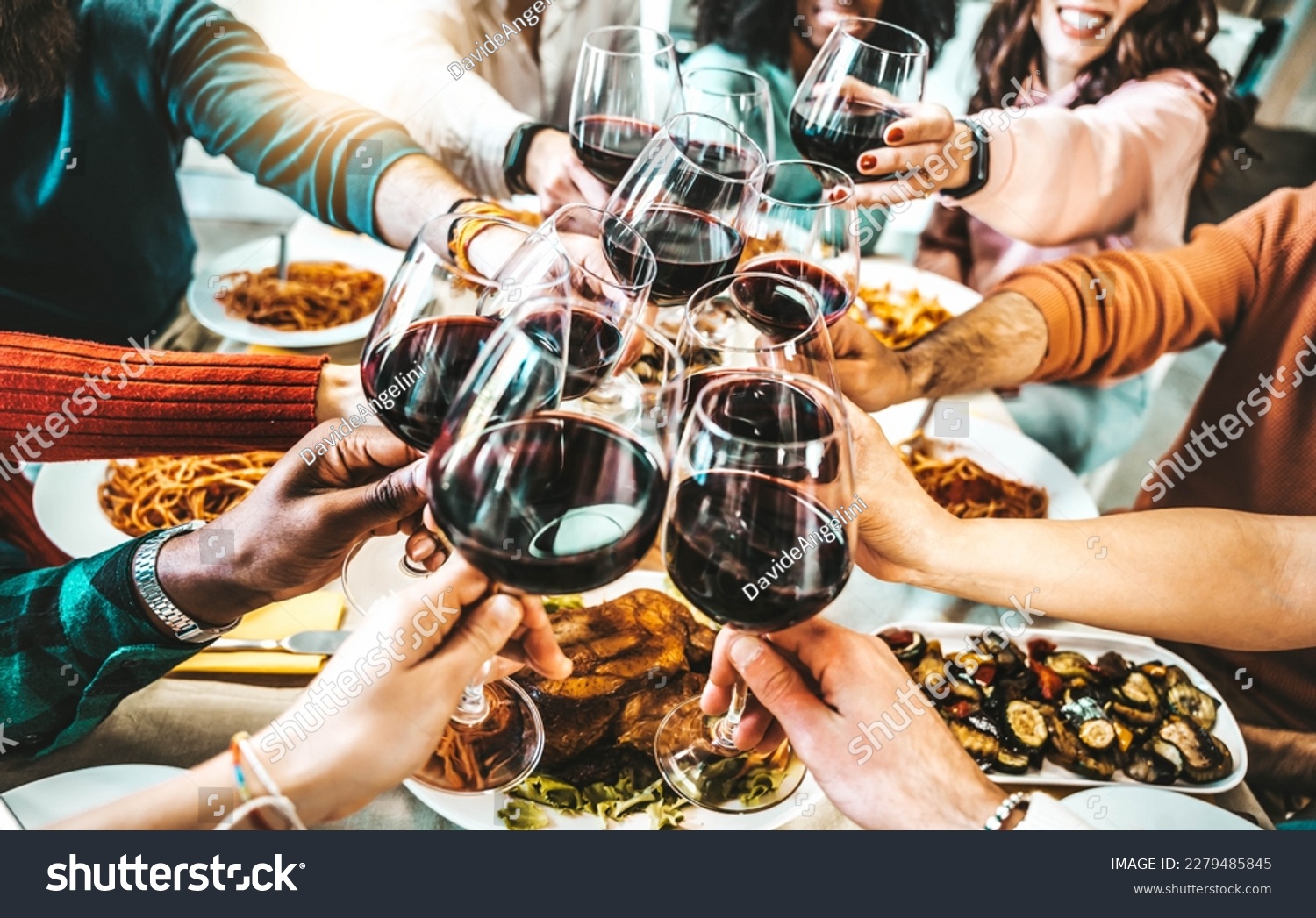 Happy friends toasting red wine glasses at dinner party - Group of people having lunch break at bar restaurant - Life style concept with guys and girls hanging out together - Food and beverage  #2279485845