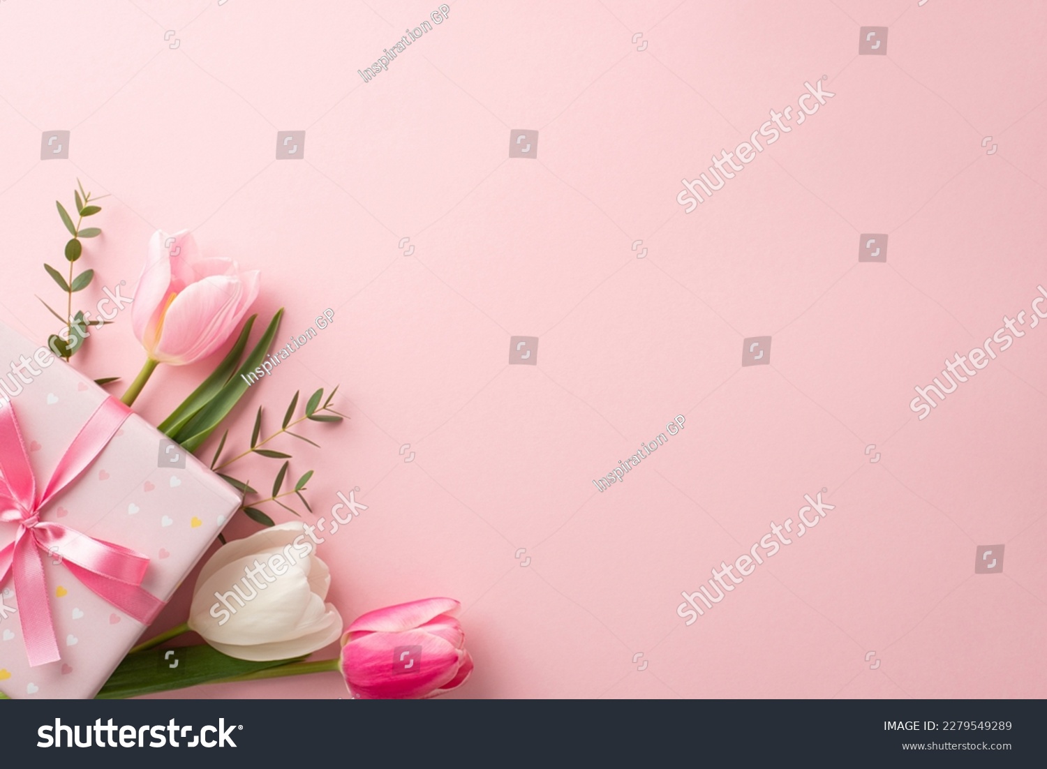 Mother's Day concept. Top view photo of stylish pink giftbox with ribbon bow and bouquet of tulips on isolated pastel pink background with copyspace #2279549289