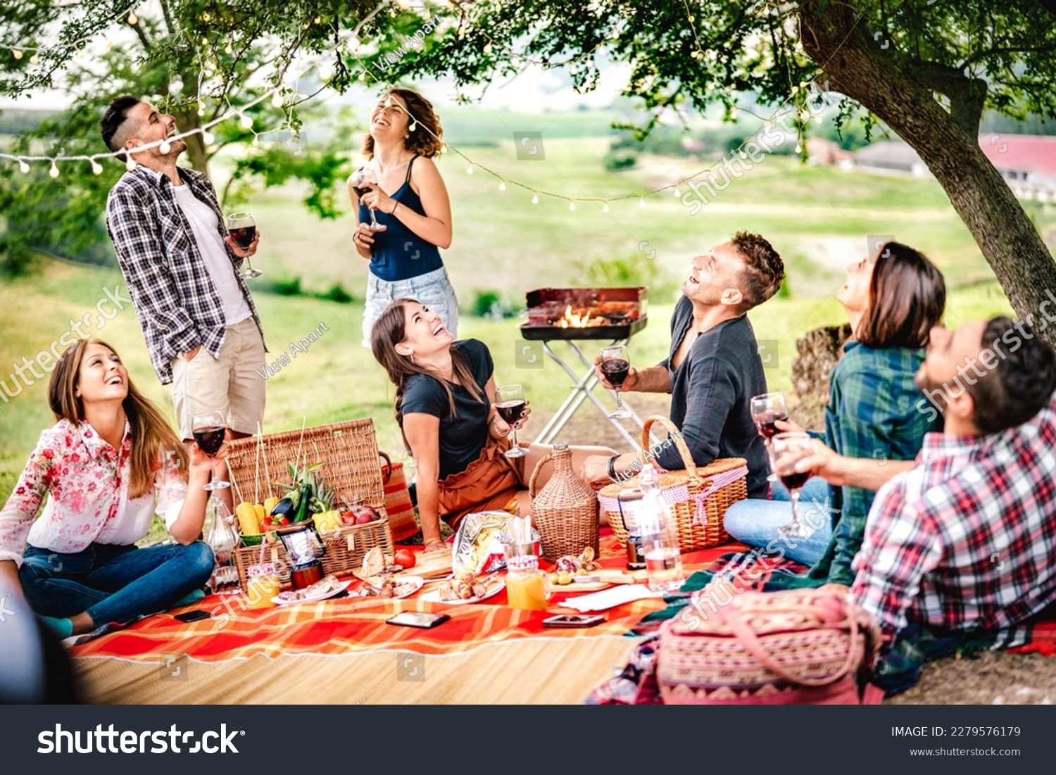 Fancy people laughing at vineyard place after sunset - Food and beverage concept with men and women drinking wine at barbeque party - Happy friends camping at open air pic nic on warm vivid filter #2279576179