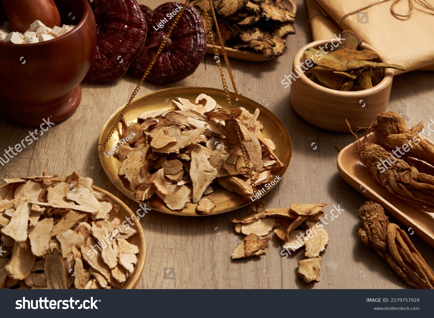 Bai Zhu placed on golden steelyard arranged with many types of herb around. Herbal medicine has played a very important role in the treatment of many different diseases #2279757929