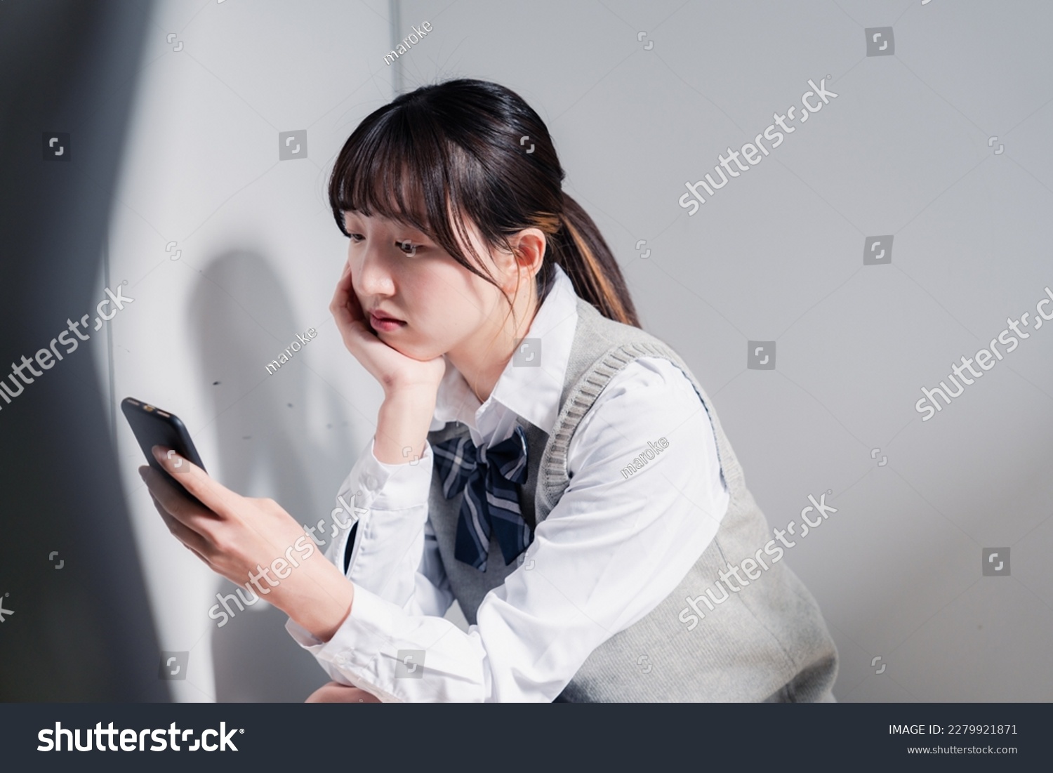 A high school girl who is depressed while looking at her phone #2279921871
