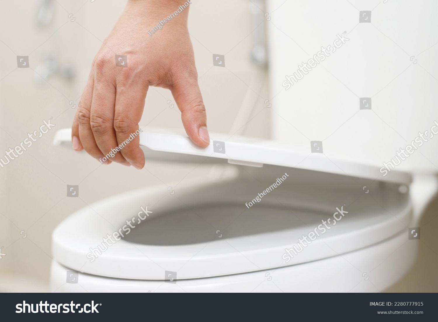 close up hand of a woman closing the lid of a toilet seat. Hygiene and health care concept. #2280777915