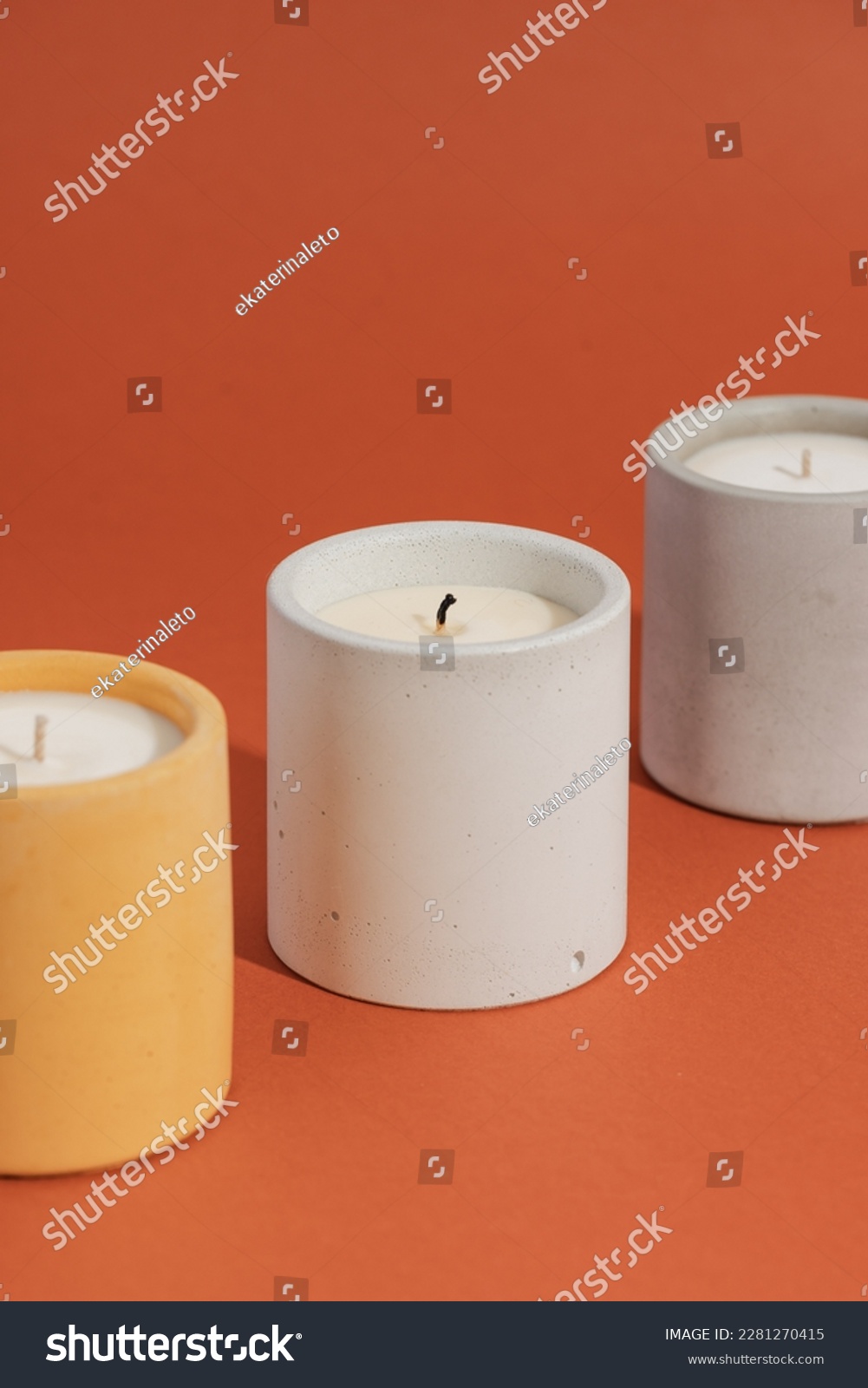 Aromatic premium soy candles in gray concrete jar on orange background. Poster banner for candle shop, beauty, spa #2281270415