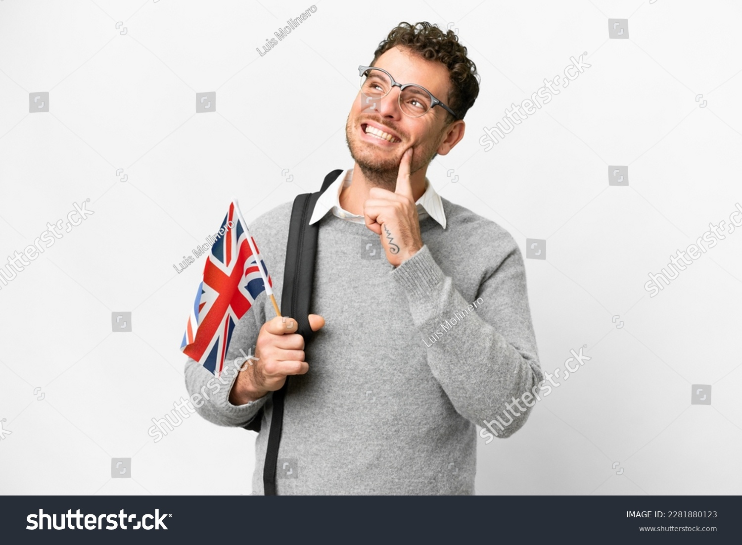 Brazilian man holding an United Kingdom flag over isolated white background thinking an idea while looking up #2281880123