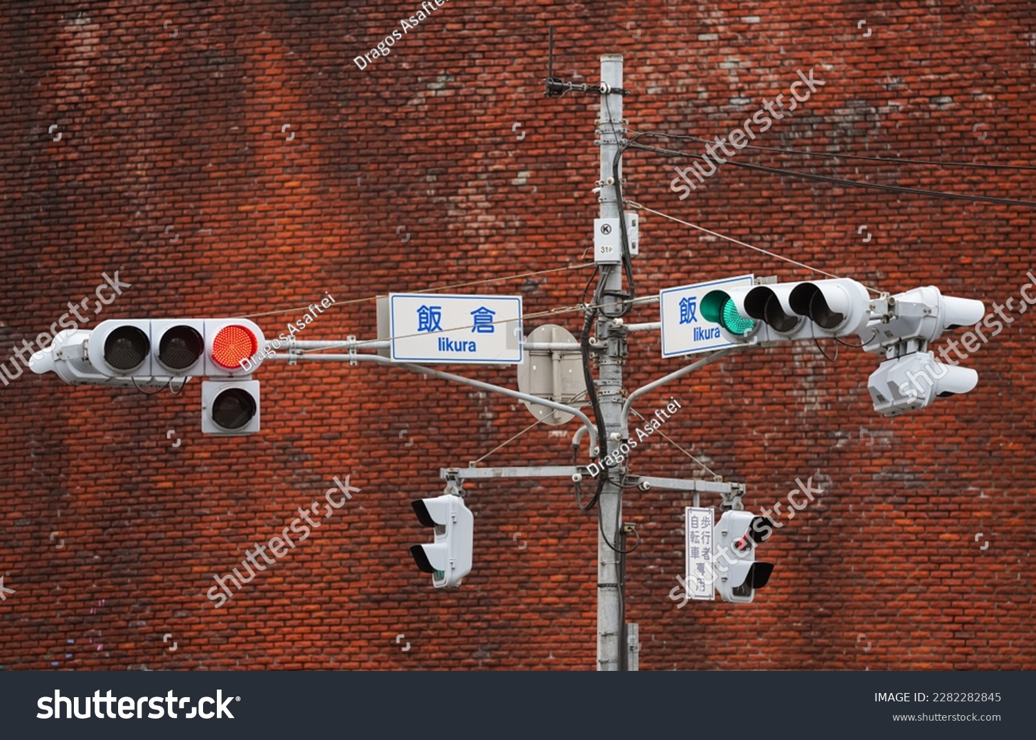 Traffic lights on standing poles over a large intersection on the streets of Tokyo. Red and green traffic lights. Transportation industry. #2282282845