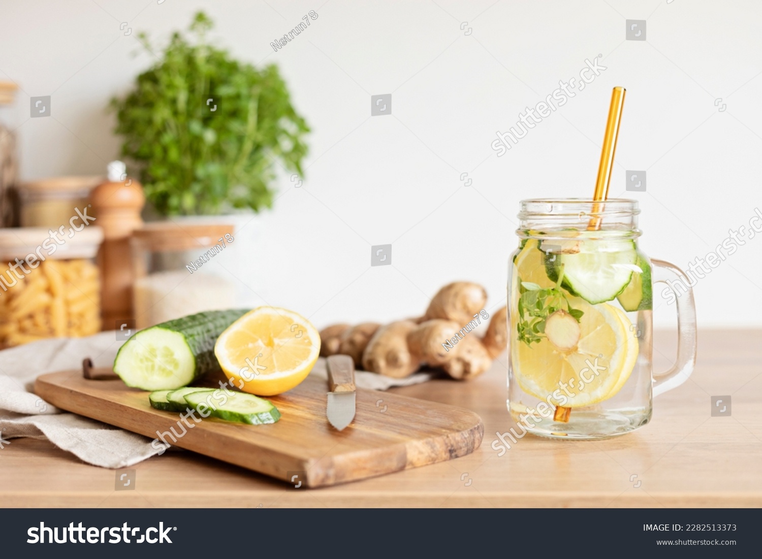 Infused  water with cucumber, lemon and ginger in glass bottle on wooden table. Diet, detox, healthy eating, weight loss concept #2282513373