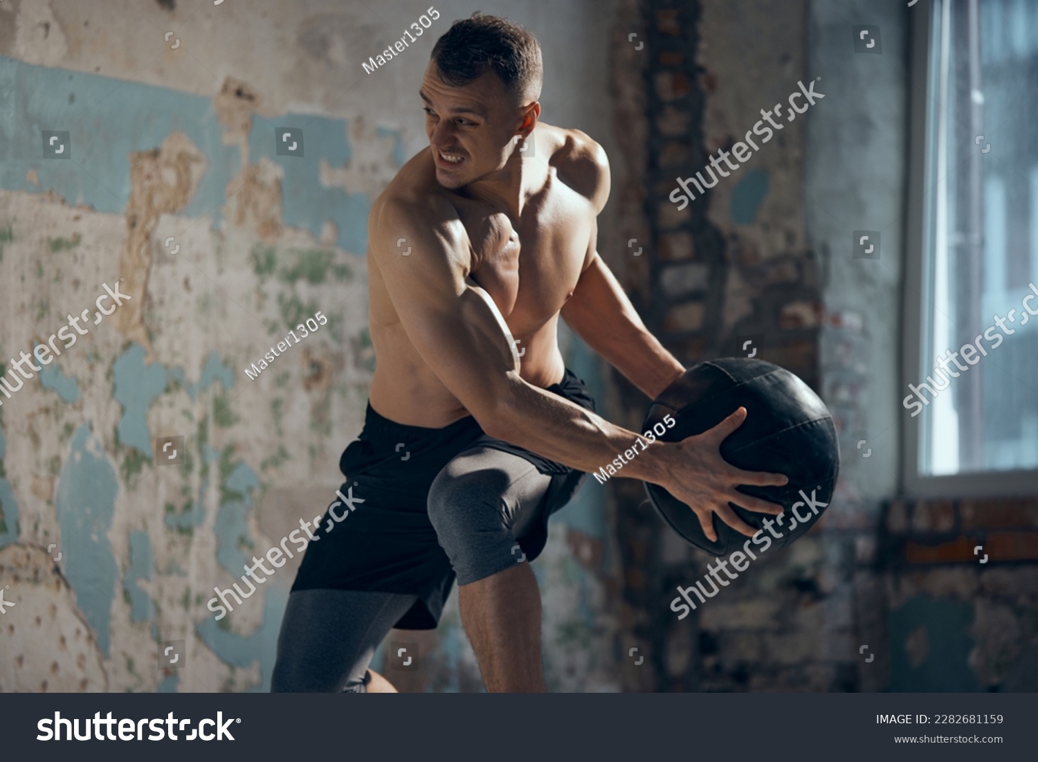 Full body workout. Young muscular man with strong, relief body shape training shirtless with fitness ball indoors. Sweat body. Concept of sportive lifestyle, body care, fitness, hobby, health #2282681159