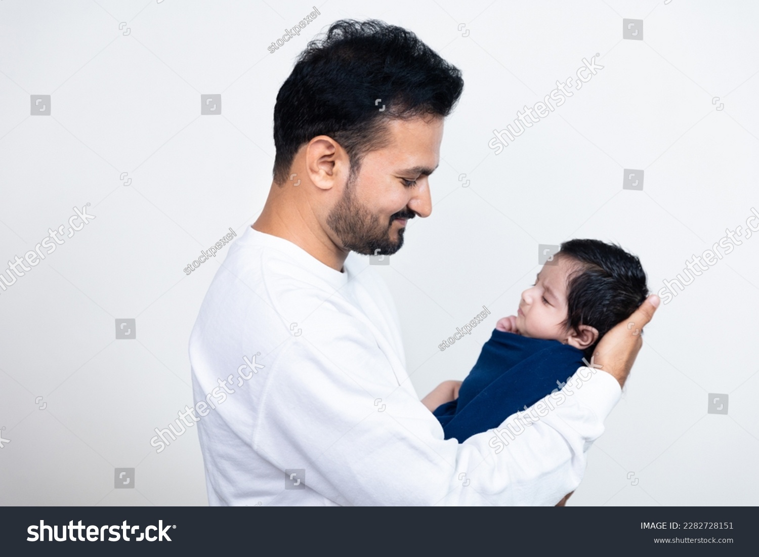 Young indian father holding cute newborn baby in arms. Loving asian dad with  small baby child, Beautiful family, fatherhood. Father's day concept. #2282728151