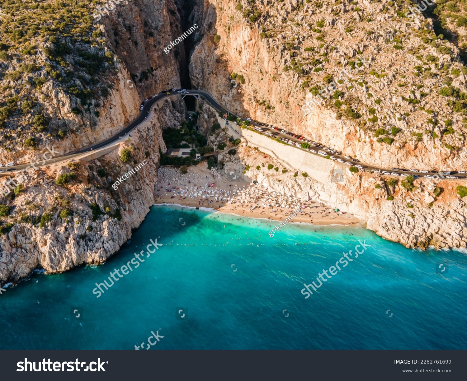 Aerial drone photograph capturing sunbathers enjoying the beautiful Kaputaş Beach in Kaş, Antalya, highlighting the vibrant atmosphere and stunning seaside landscape of this popular vacation spot. #2282761699
