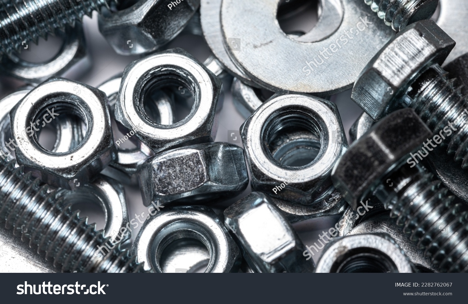 Bolts, nuts and washers in close-up scattered on a white background. Background with metal elements. #2282762067