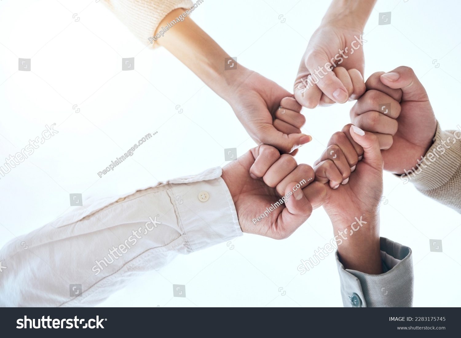 Below business people, fist bump and circle for team building, support and group goals in workplace. Men, women and teamwork with solidarity for success, motivation and trust with diversity at job #2283175745