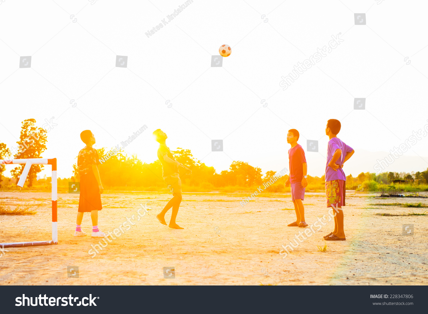 Group of the kids (boys) are playing football for exercise in the sunshine day. #228347806