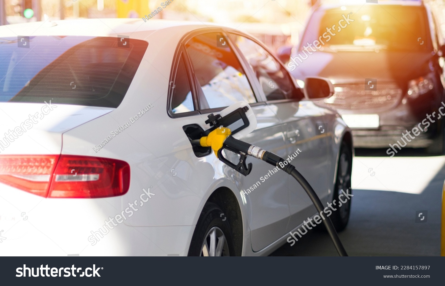 Refuel cars at the fuel pump. The driver hands, refuel and pump the car's gasoline with fuel at the petrol station. Car refueling at a gas station. #2284157897
