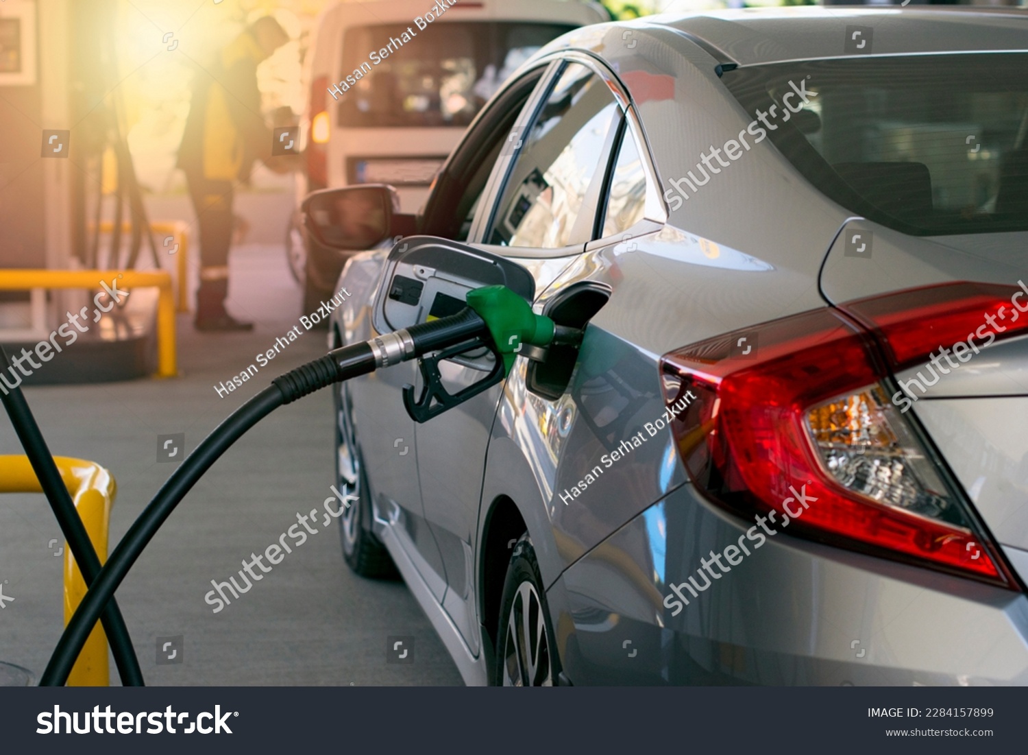 Refuel cars at the fuel pump. The driver hands, refuel and pump the car's gasoline with fuel at the petrol station. Car refueling at a gas station. #2284157899