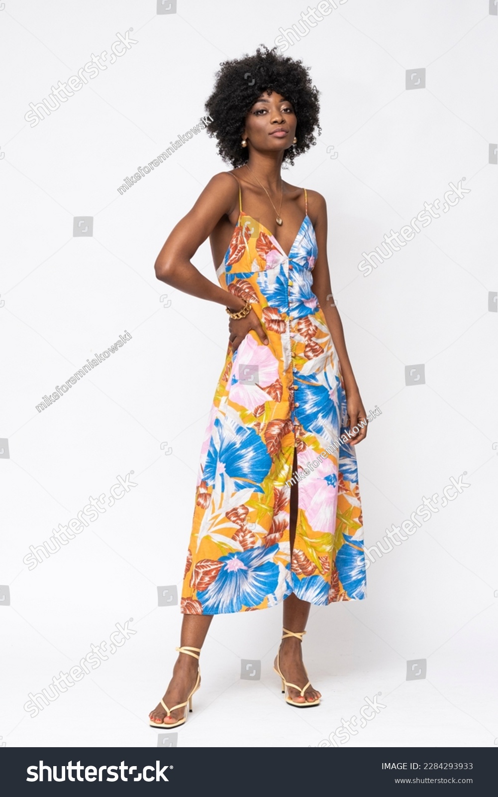 Fashionable African woman with curly hairs and floral dress on isolated white background. #2284293933