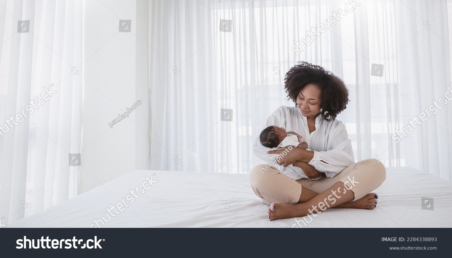 Close up portrait of beautiful young African American  mother holding sleep newborn baby in hospital bed room. Healthcare medical love black afro woman lifestyle mother's day, breast with copy space. #2284338893
