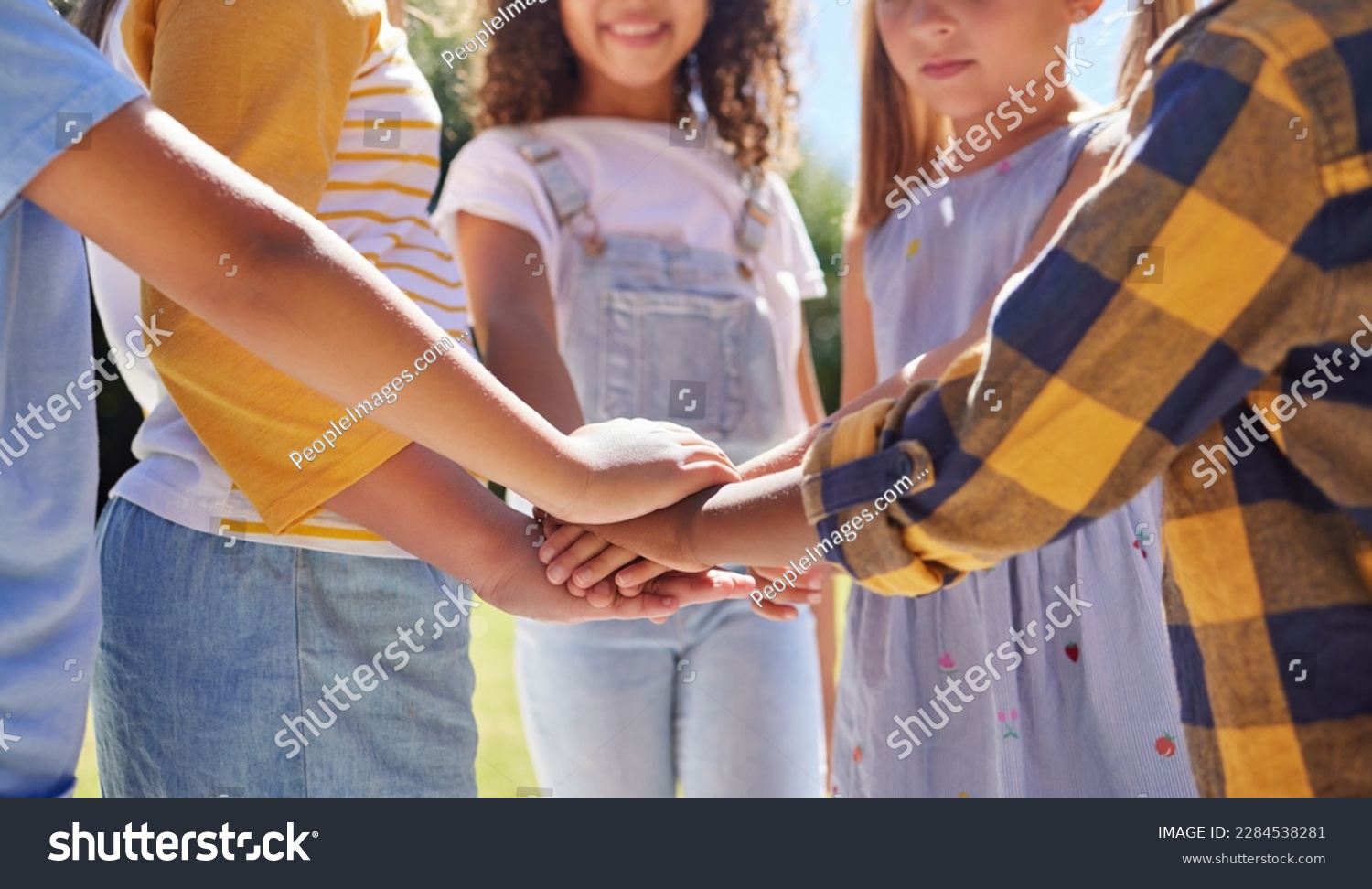 Hands together, support and children outdoor, solidarity and trust with motivation, games or growth. Closeup, kids or youth group with gesture for teamwork, commitment or fun with development or goal #2284538281