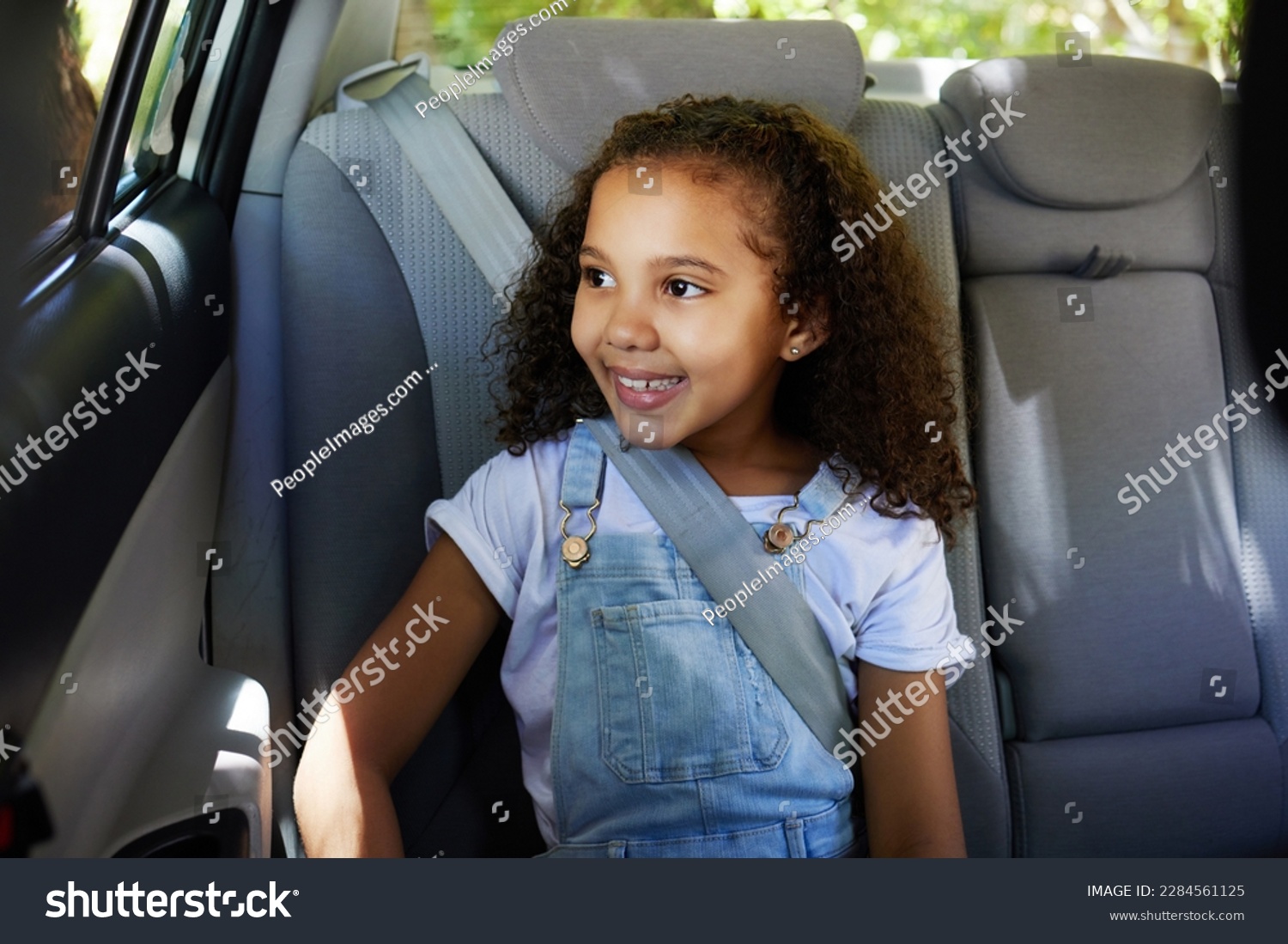 Road trip, girl child and happy in car backseat for travel, journey and drive, happy and relax. Smile, kid and little passenger enjoying drive in vehicle for adventure, vacation or weekend traveling #2284561125