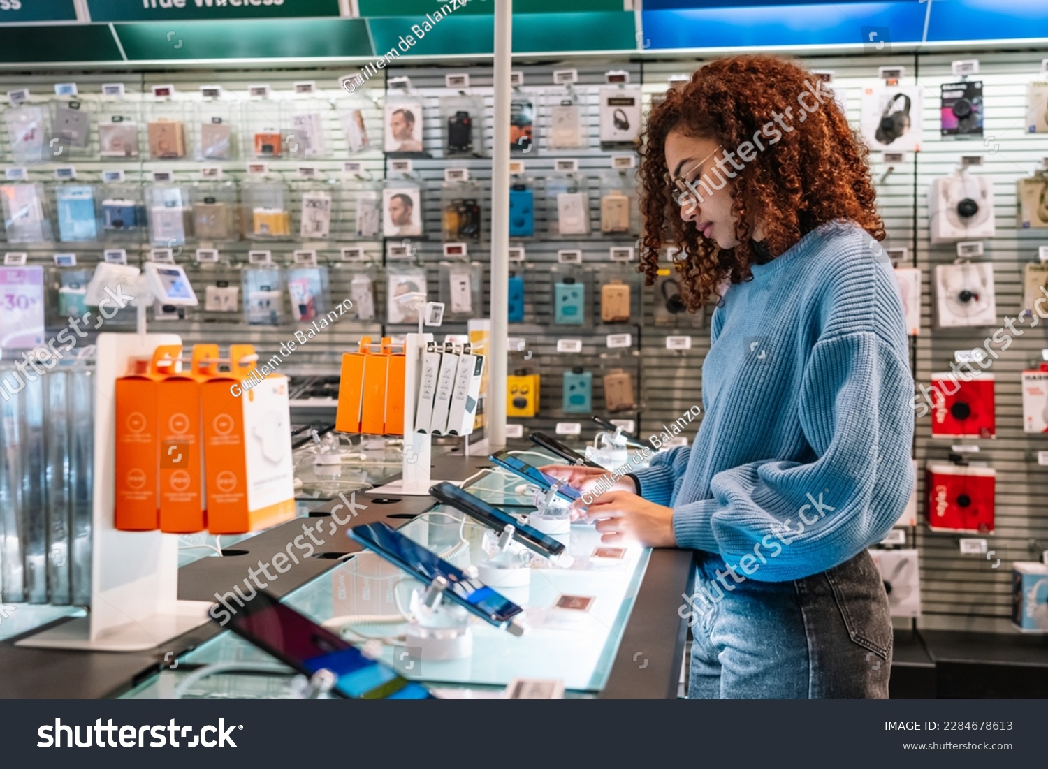African American woman touching phone screen in shop #2284678613