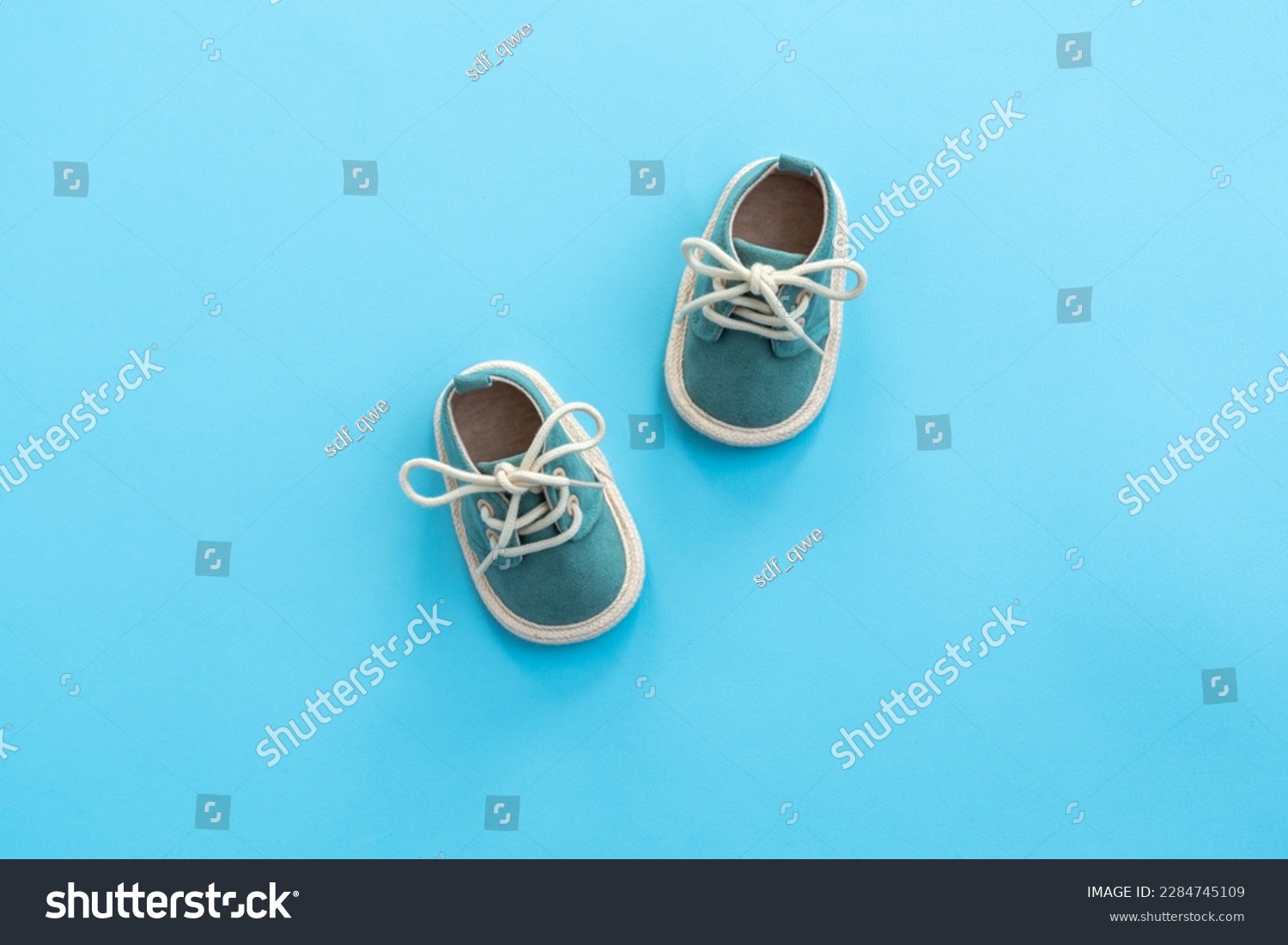 Baby shoes on paper background with copy space. Baby clothes concept. Top view, flat lay #2284745109