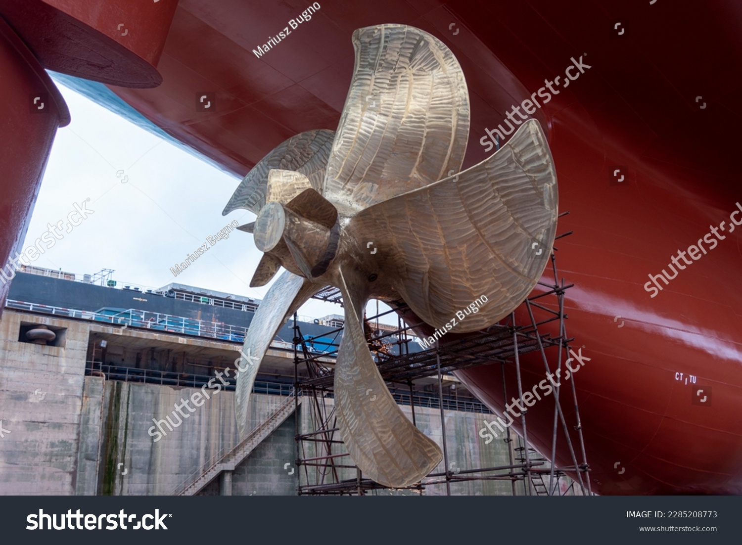 View on the container ship propeller. Ship is inside a dry dock for routine maintenance and painting. #2285208773