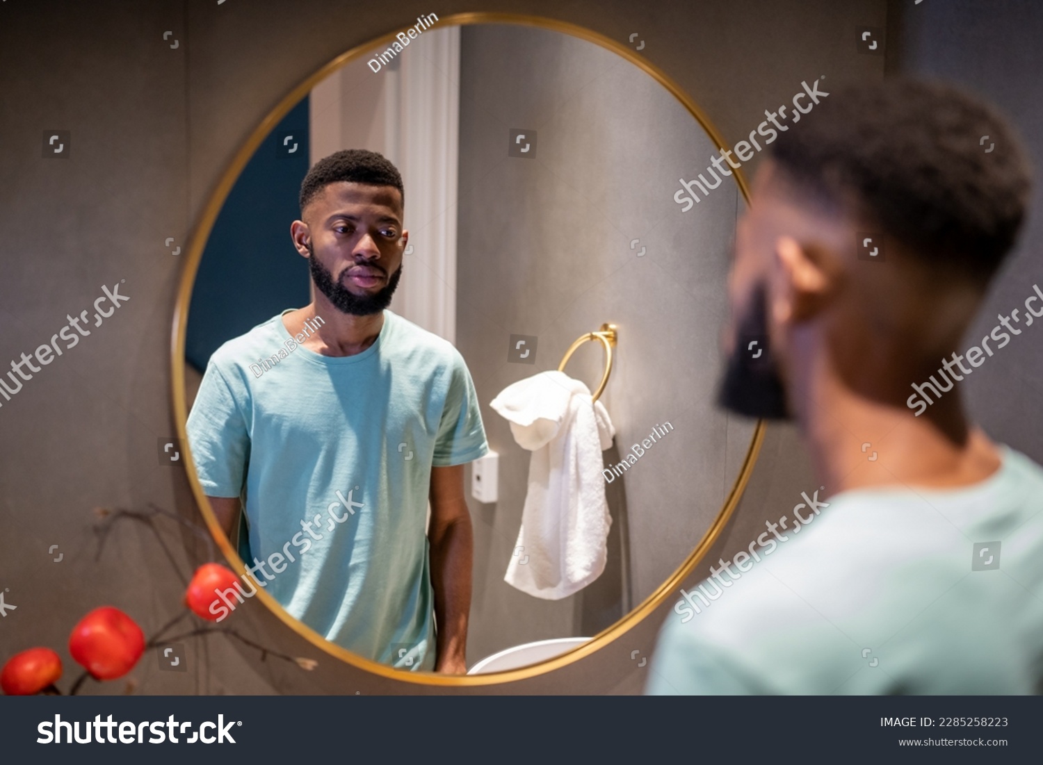 Unhappy upset 30s African American man looking in mirror, standing in bathroom at home, sad depressed black guy feeling dissatisfied with his appearance. Midlife crisis in men #2285258223