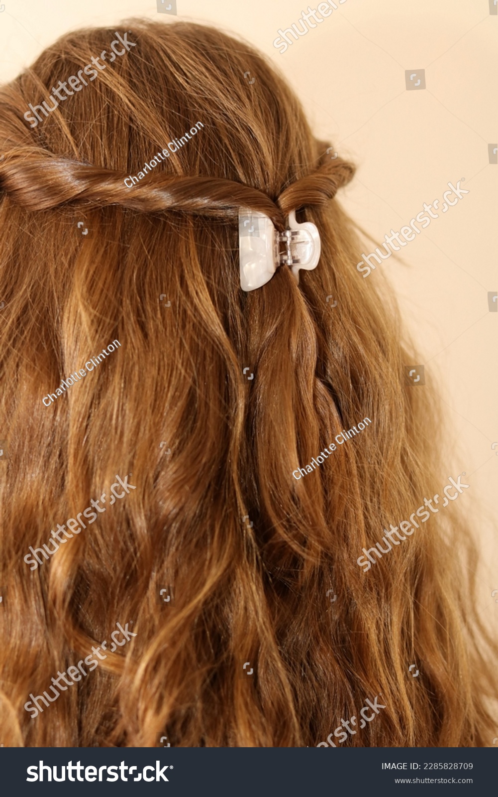 Dark blonde hair twisted back and clasped in a claw clip. Pearlescent hair clip. Trendy hairstyle. Boho hairstyle. Healthy, shiny hair.  #2285828709