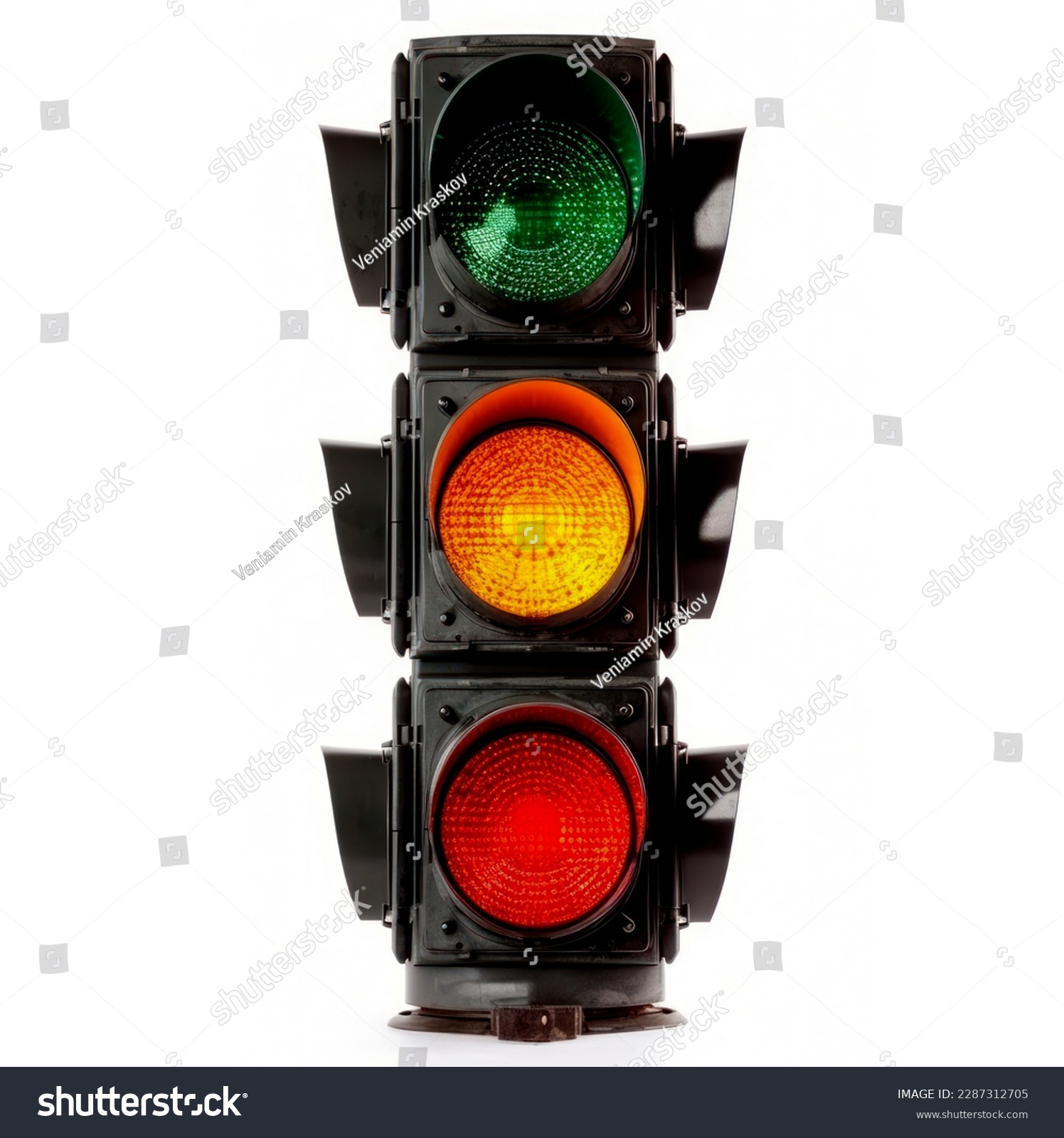 The traffic light is isolated on a white background. All three lights on the traffic light are on. #2287312705