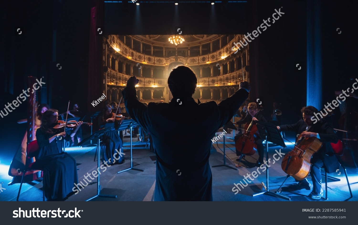 Back View Cinematic shot of Conductor Directing Symphony Orchestra with Performers Playing Violins, Cello and Trumpet on Classic Theatre with Curtain Stage During Music Concert #2287585941