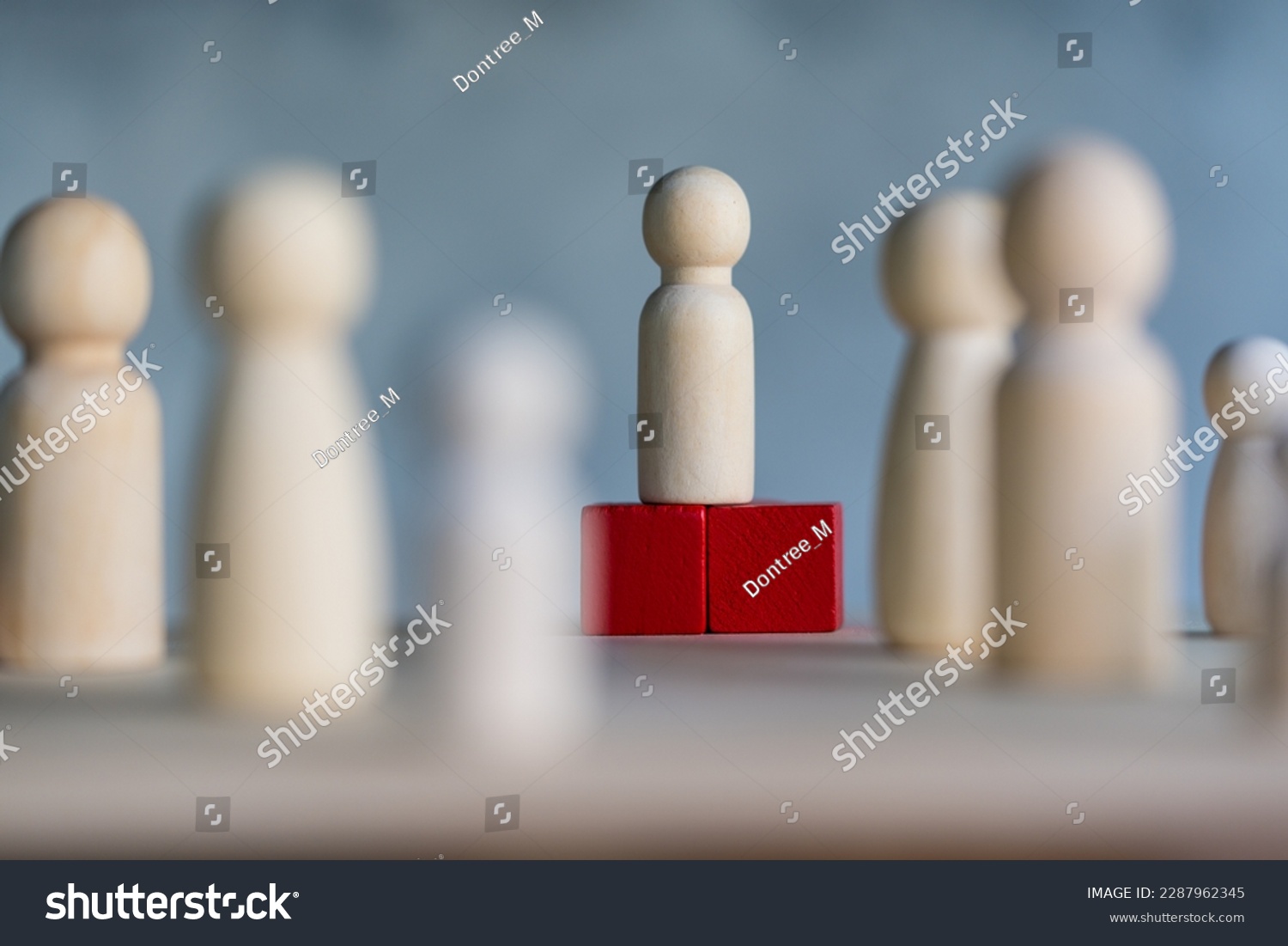 Wooden figures and peg dolls standing on the red podium 1st positions of wooden cube blocks. Ranking and strategy concept. Leadership concept and business strategy. Selective focus #2287962345