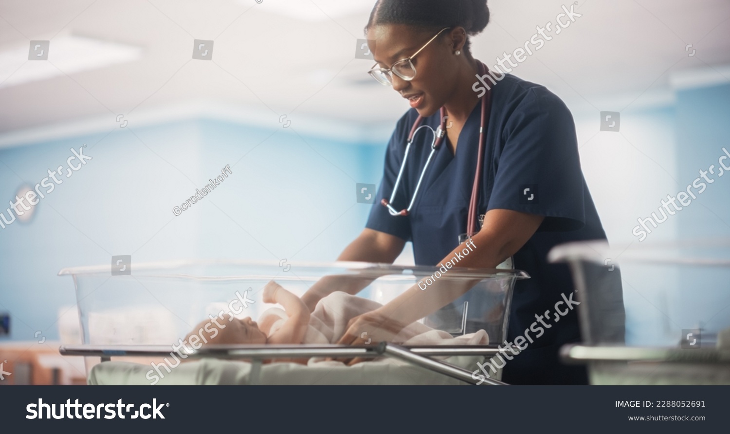 Portrait of a Young Doctor Checking Up and Caring for a Newborn Baby Lying in a Bassinet in a Modern Maternity Ward. Cute Neonate Healthy Child Waiting for Mother to Take the Baby Home #2288052691