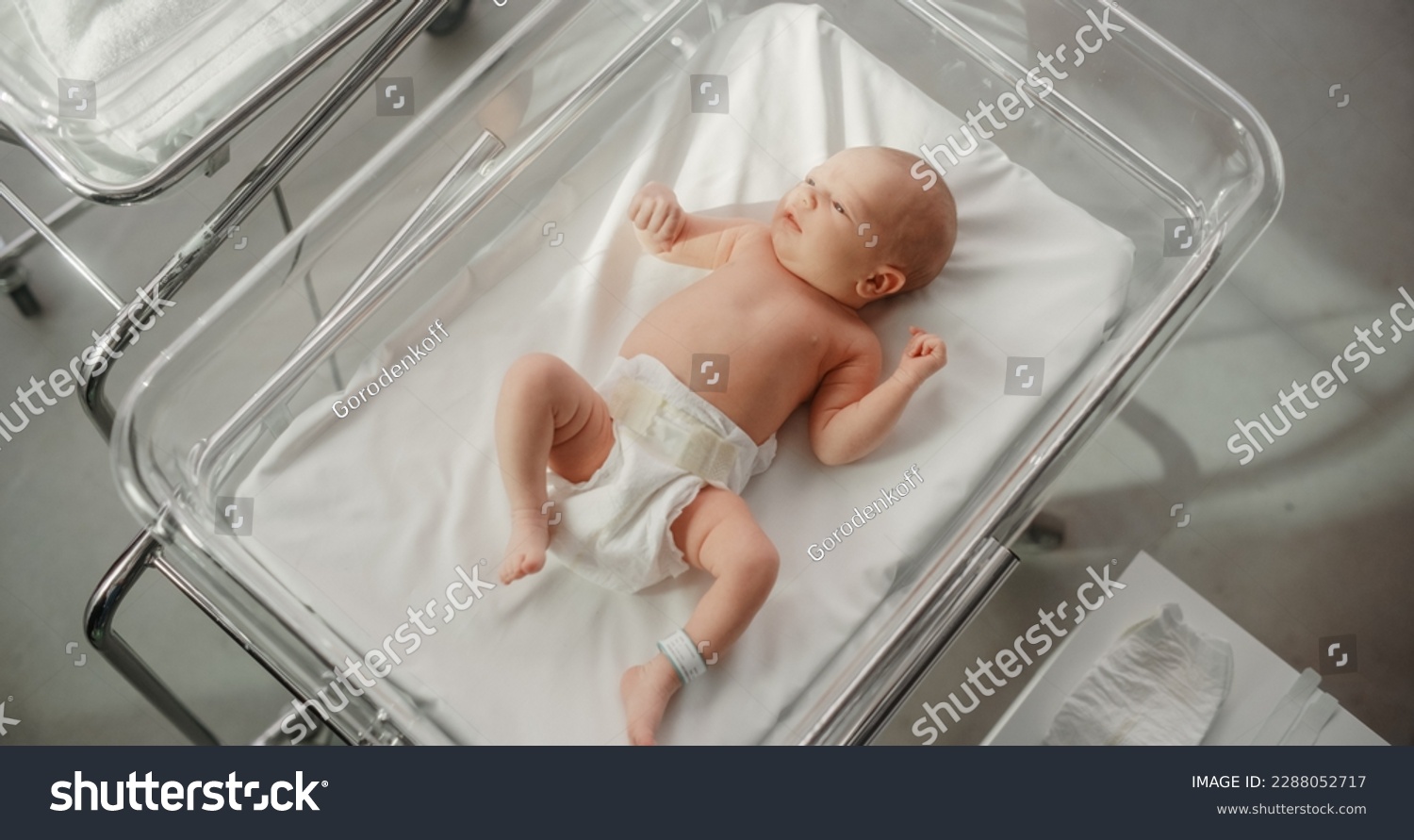 Adorable Caucasian Newborn Child Lying in Hospital Bed in a Nursery Clinic. Little Playful and Healthy Baby. Medical Health Care, Maternity and Parenthood Concept #2288052717