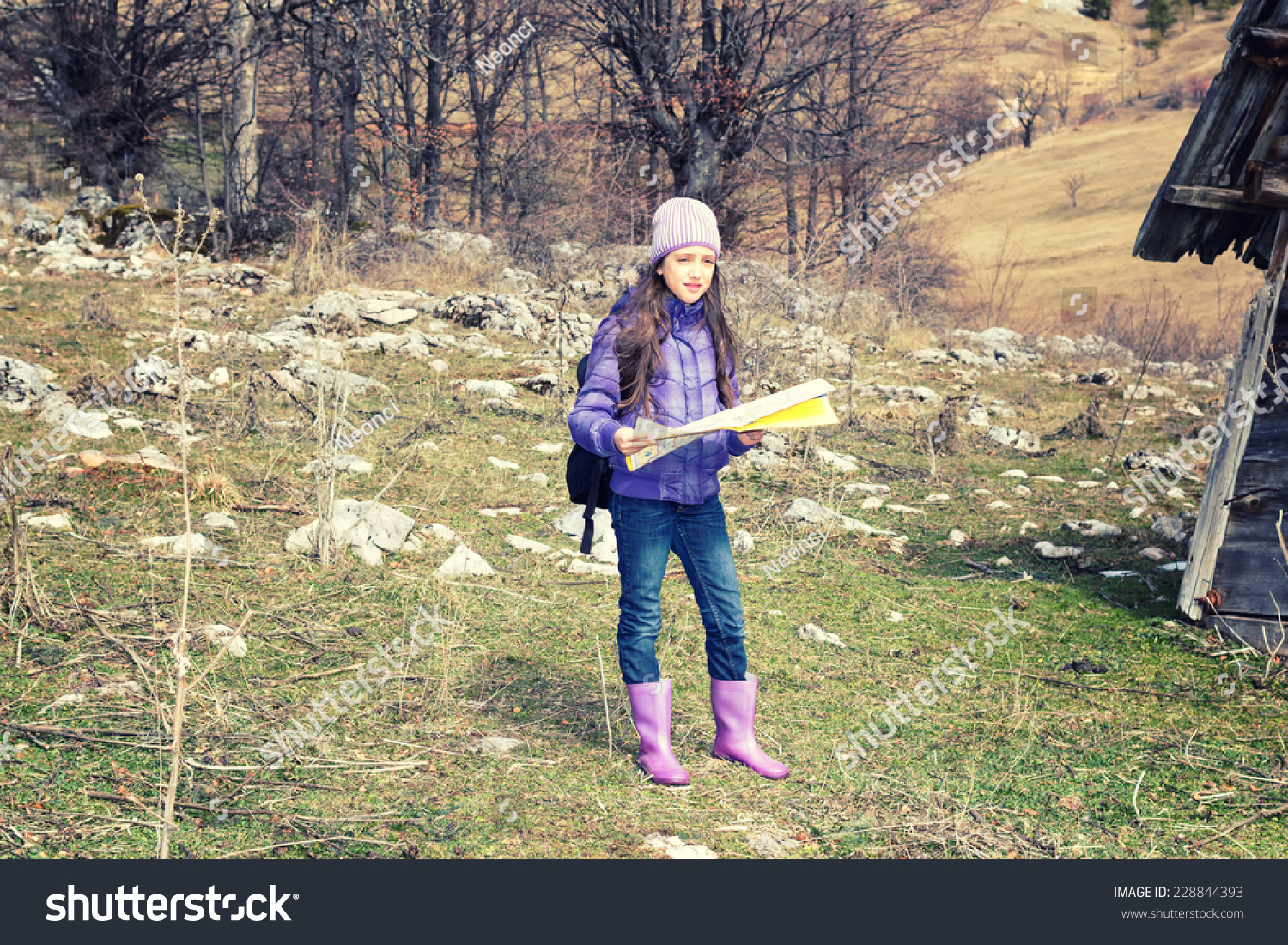Young girl in countryside looking for directions on the map.Cross processed. #228844393