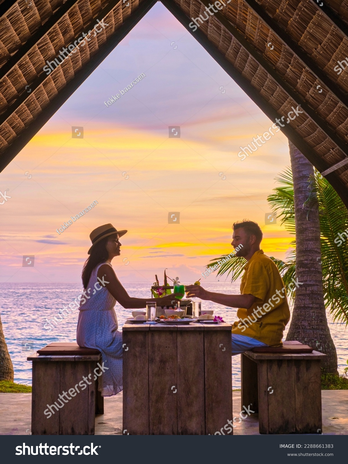 Romantic dinner on the beach with Thai food during sunset on the Island of Koh Mak Thailand. Couple of men and women having a romantic dinner on the beach #2288661383