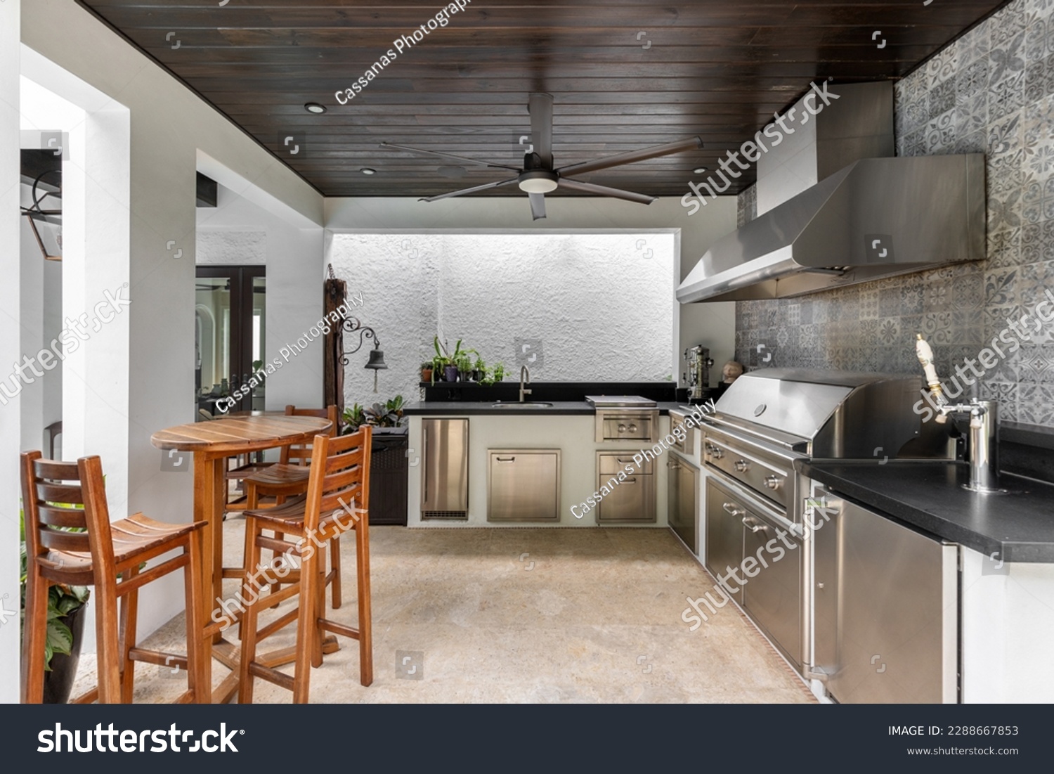 Modern outdoor kitchen and. luxury with grill, stove, extractor hood, wooden ceiling with fan, wooden tables and benches, chop tap, tiled wall.
Located in Coral Gables, Miami, FL, USA #2288667853