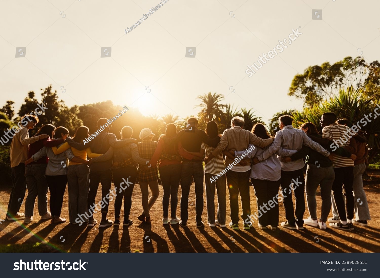 Back view of happy multigenerational people having fun in a public park during sunset time - Community and support concept  #2289028551