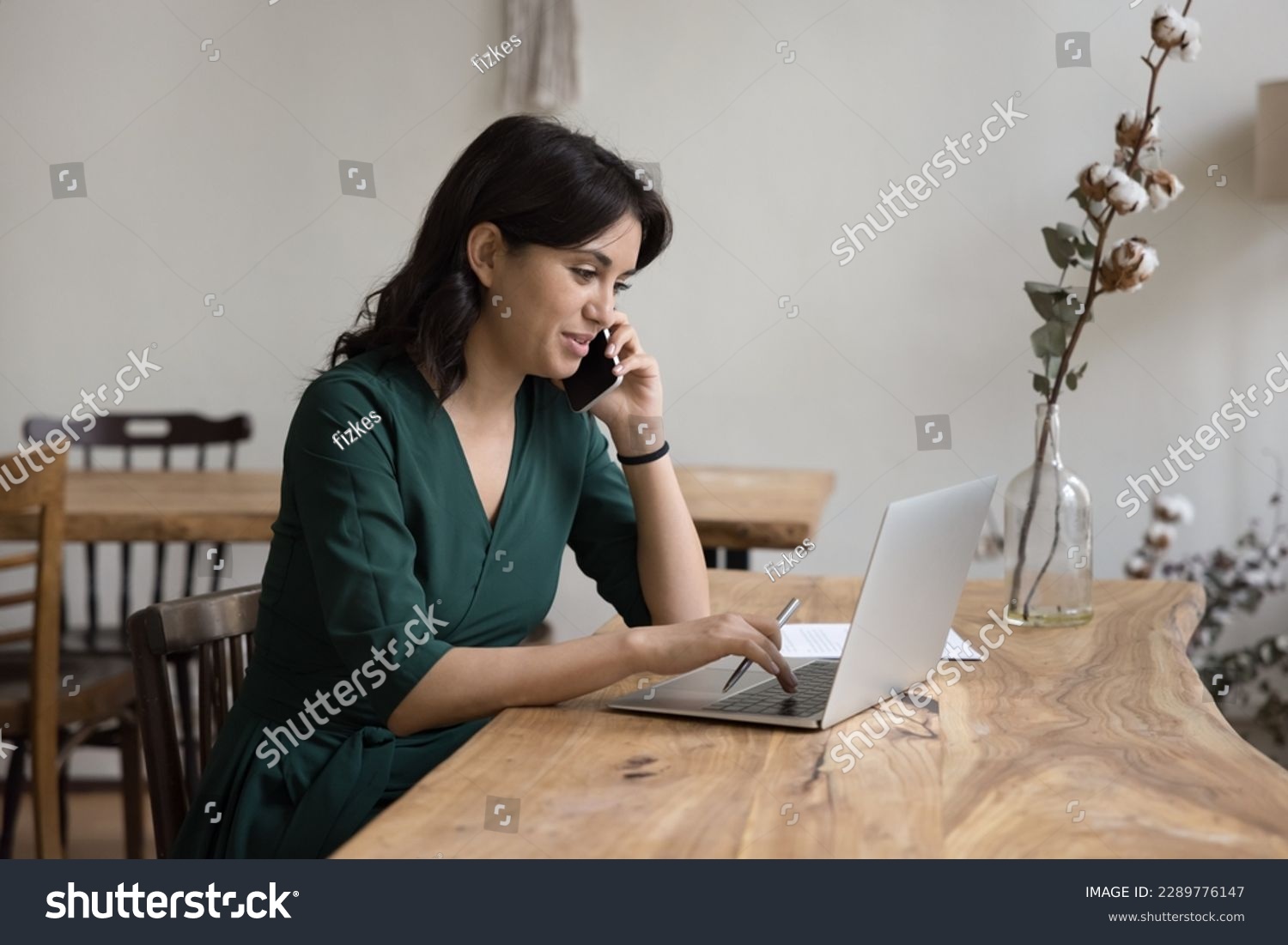 Businesswoman sits at desk, calling by business, provide consultation remotely, lead formal conversation to client, use laptop working in cozy office, make order engaged in workflow using modern tech #2289776147