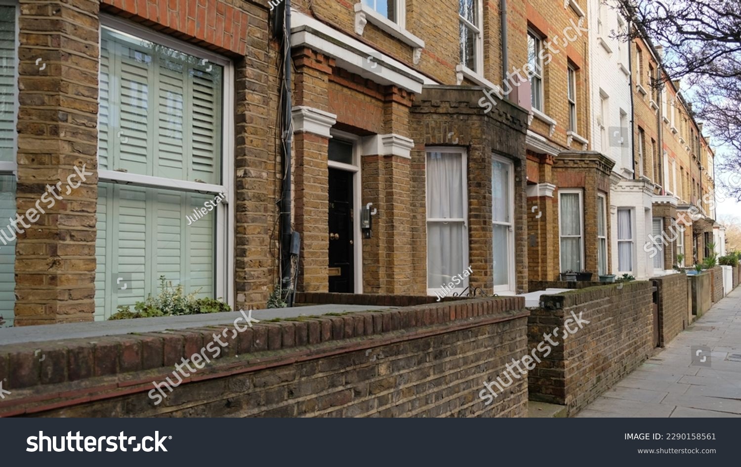 Typical Victorian terraced houses in England. Exterior view of cozy residential buildings in London with brick fence, several floors, windows and front door with molding. Real estate, Living apartment #2290158561
