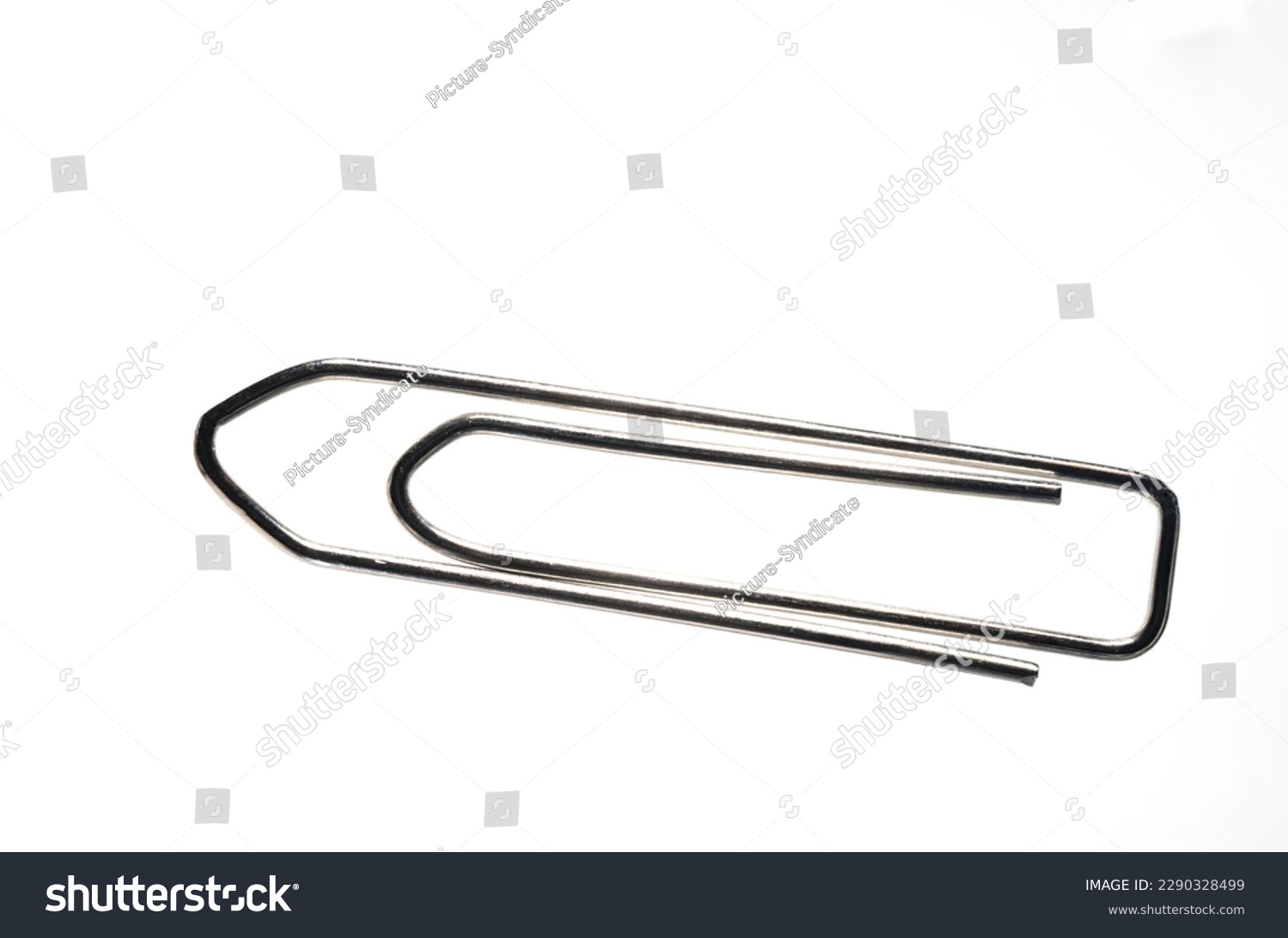 Extreme close up of large silver metal paper clip against white background with copy space as concept for office paperwork and administration #2290328499