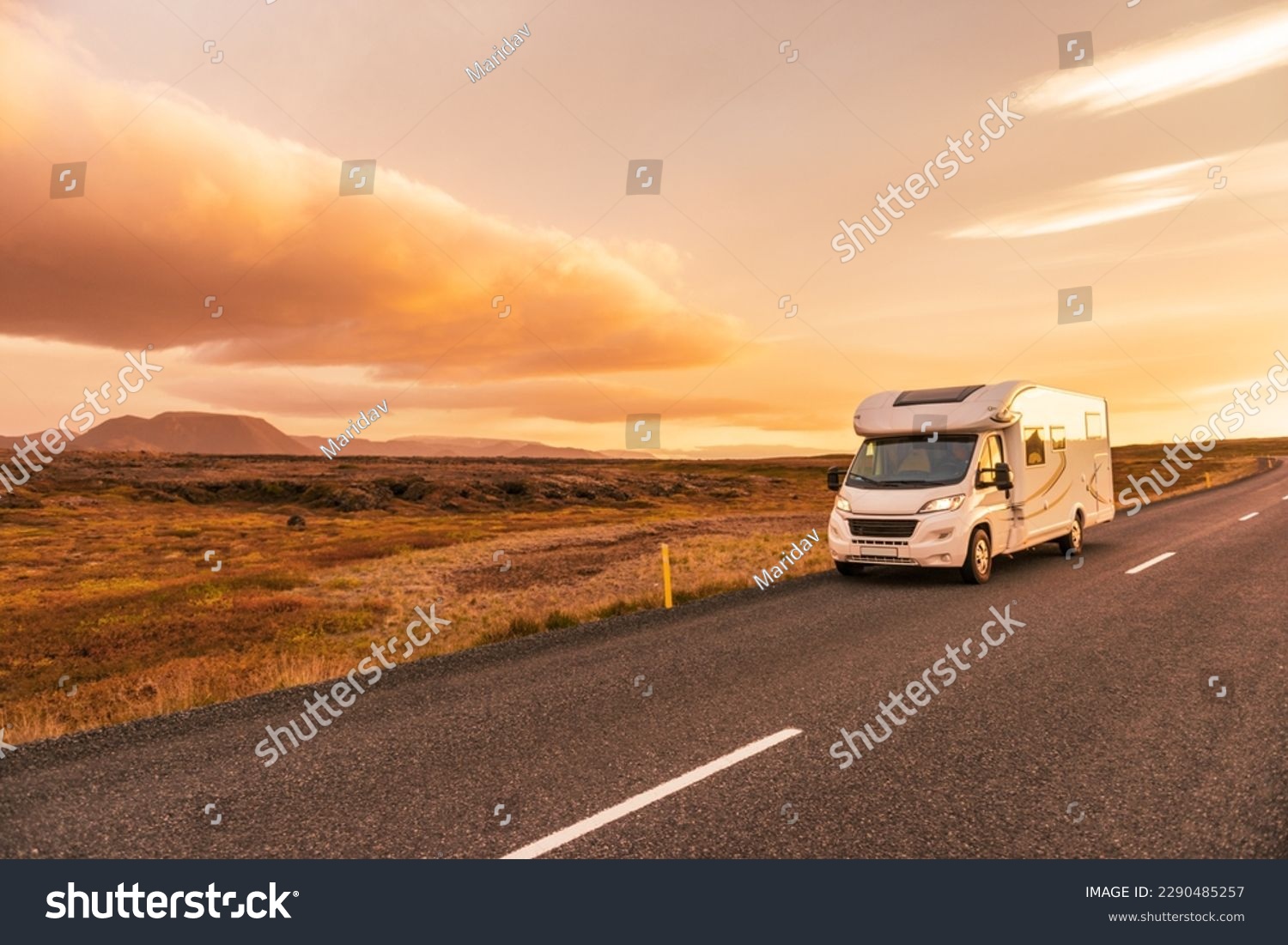 RV Motorhome camper van road trip. People on travel vacation adventure. Tourists in rental car campervan by view of mountains in beautiful nature landscape at sunset. From Iceland. #2290485257