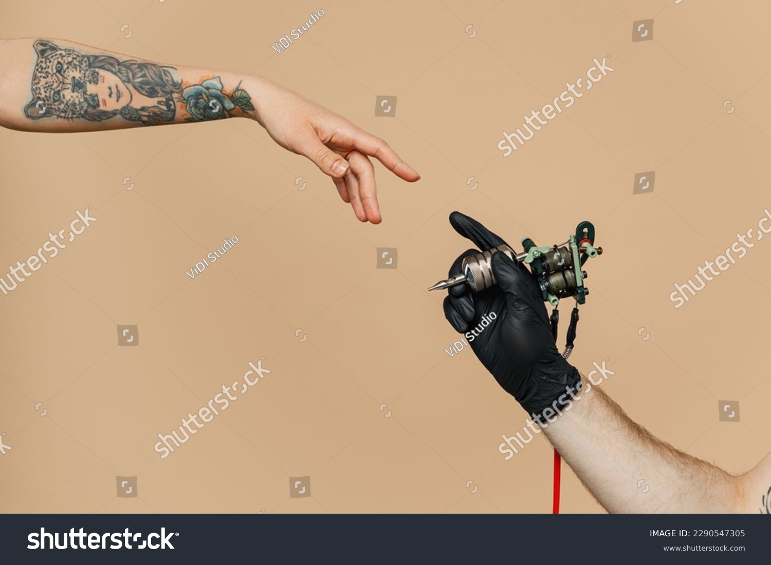 Close up cropped photo of tattooer master artist male hold in hand machine black ink in jar, equipment for making tattoo art on body, touch female finger arm isolated on pastel plain beige background #2290547305