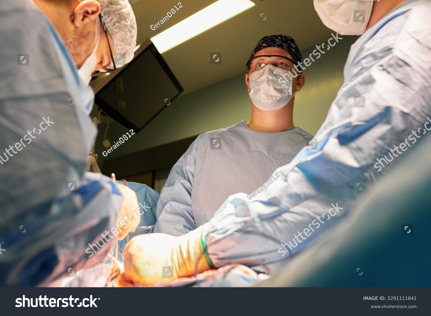 Surgeon face in operating room, stressful operation, surgeon performs operation in modern operating room with activity life support devices and light lamps, life saving, inoperable sarcoma. #2291111841