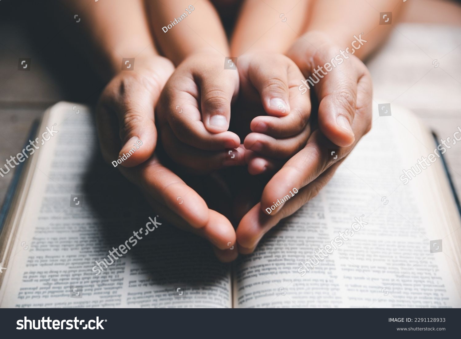 Christian family praying together concept. Child and mother worship God in home. Woman and boy hands praying to god with the bible begging for forgiveness and believe in goodness. #2291128933