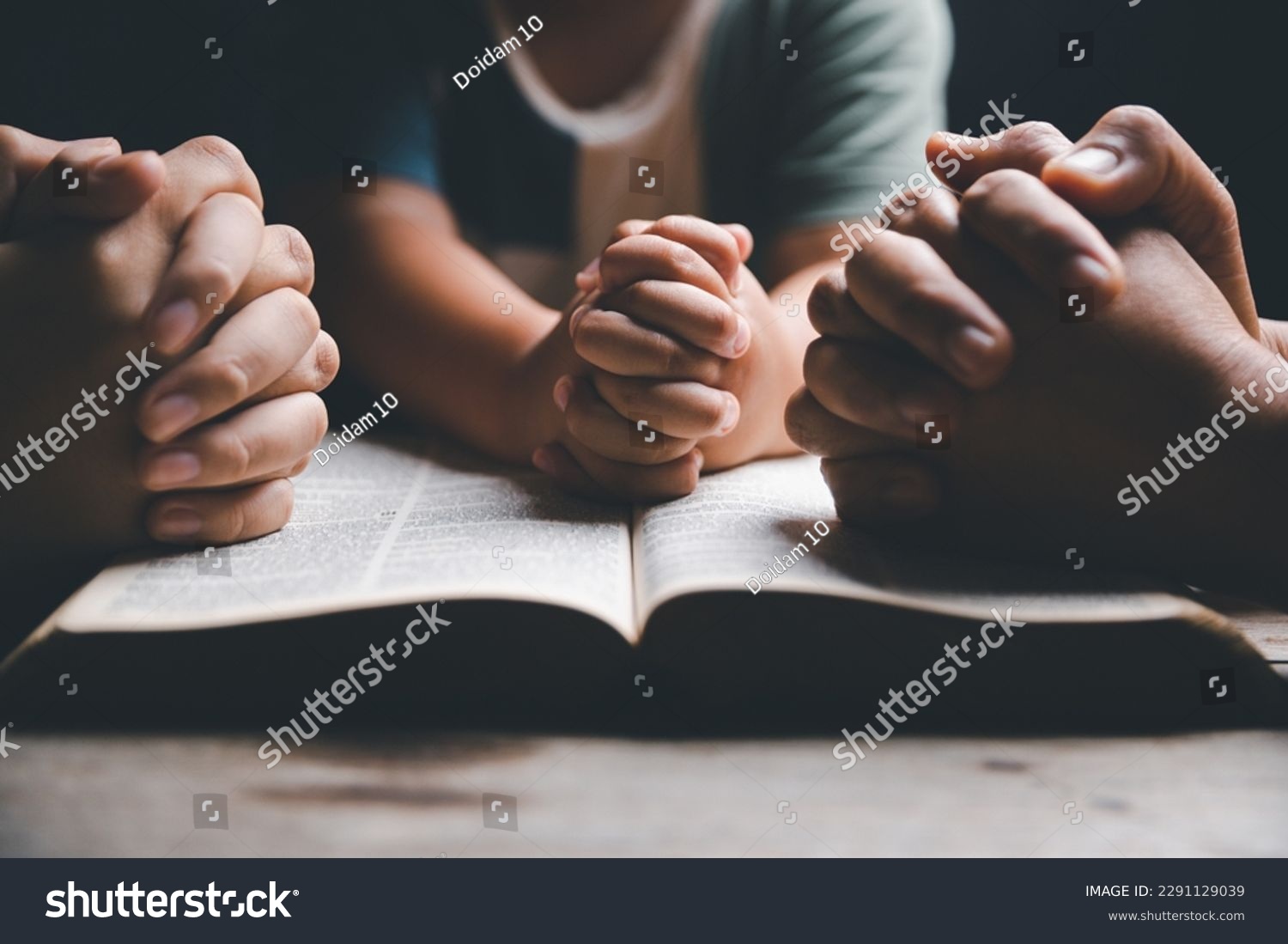 Christian family praying together concept. Child and mother worship God in home. Woman and boy hands praying to god with the bible begging for forgiveness and believe in goodness. #2291129039