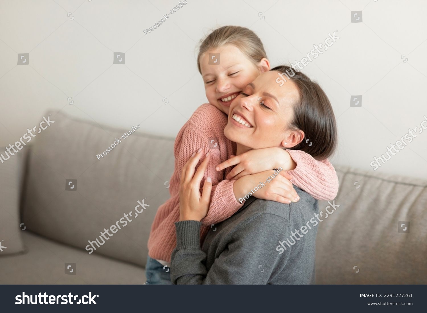 Cheerful happy cute european teen girl hugging millennial mom, have fun, enjoy spare time in living room interior, free space. Love, support, care and relationships at home #2291227261