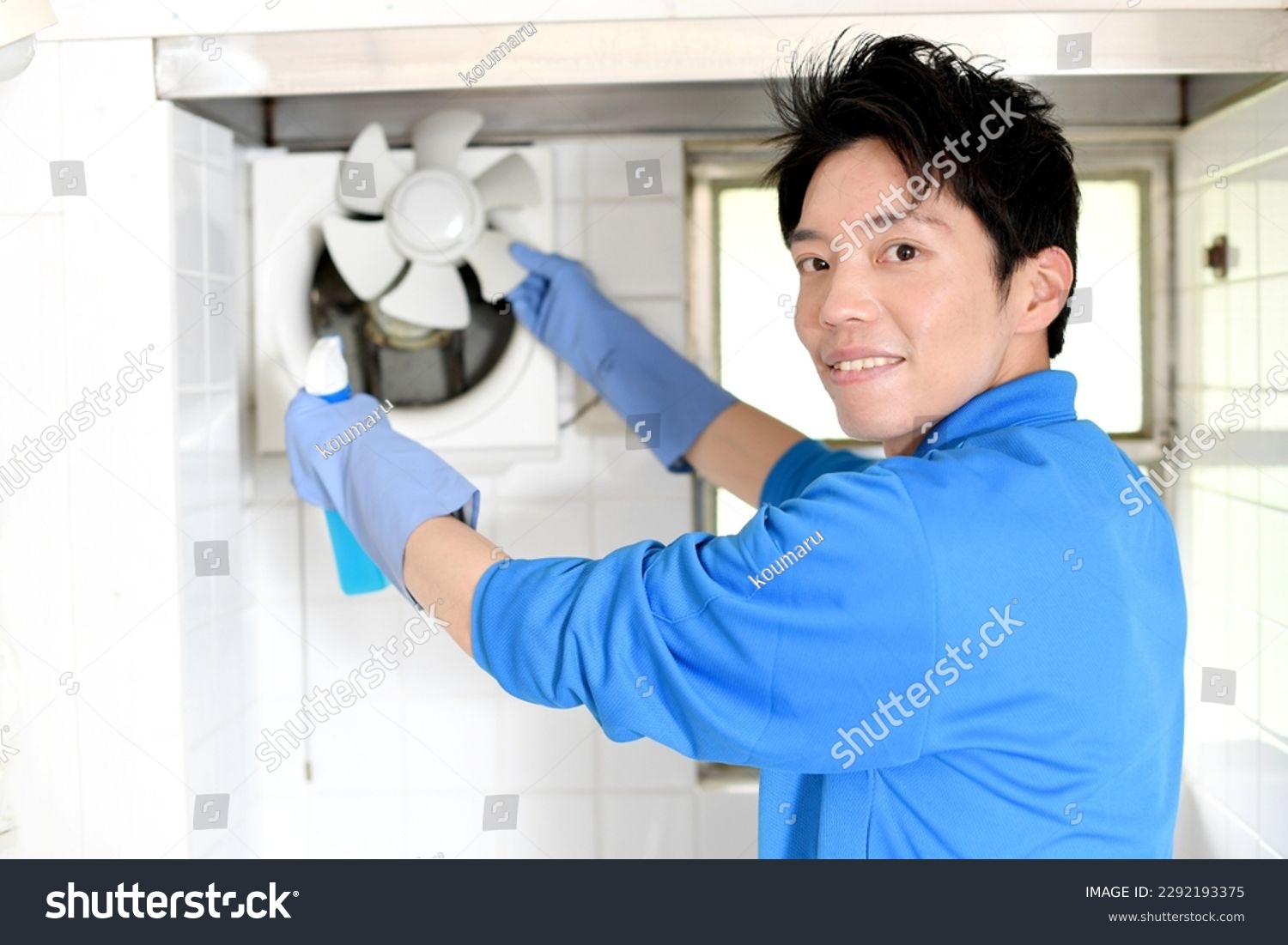 A male worker in the cleaning industry cleaning the ventilation fan #2292193375