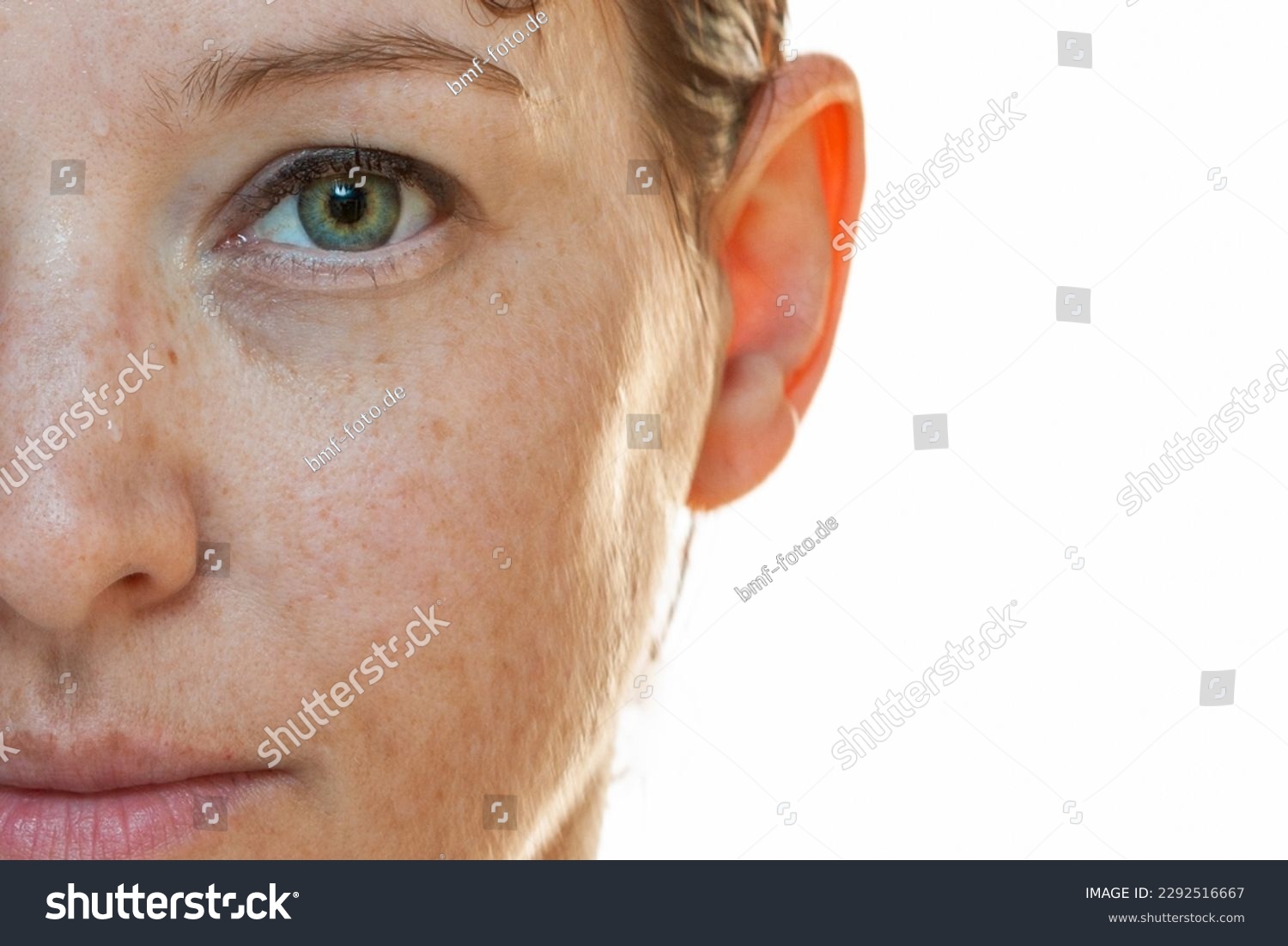 Naturally strong portrait half-sided of a woman without make-up with sun spots on her face #2292516667